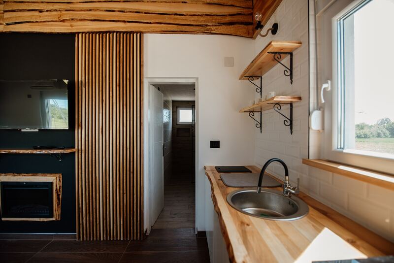 Kitchen with a wooden worktop, open shelves and exposed timber ceiling beams